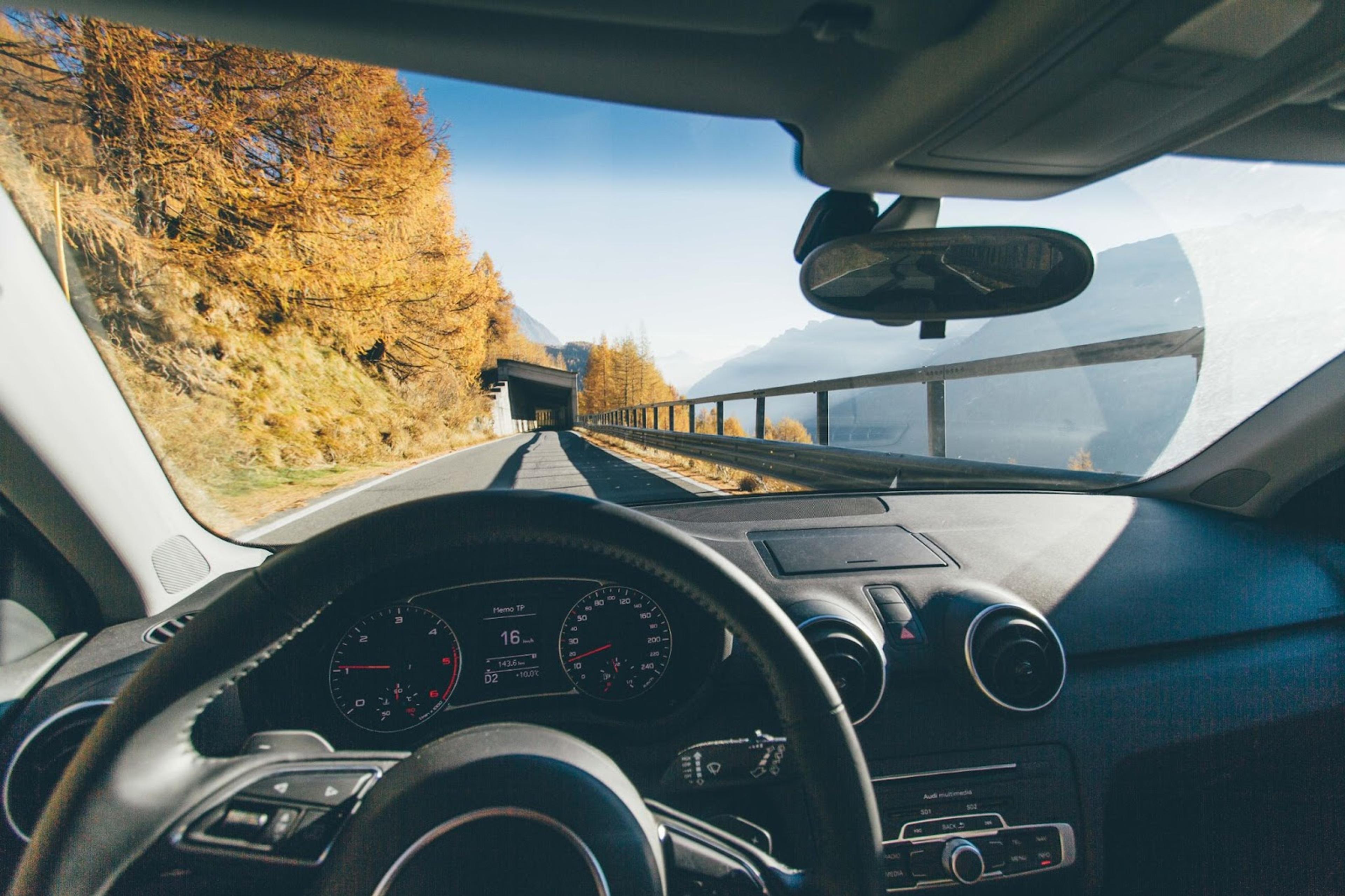 Interior del coche desde el punto de vista del conductor en una carretera en otoño